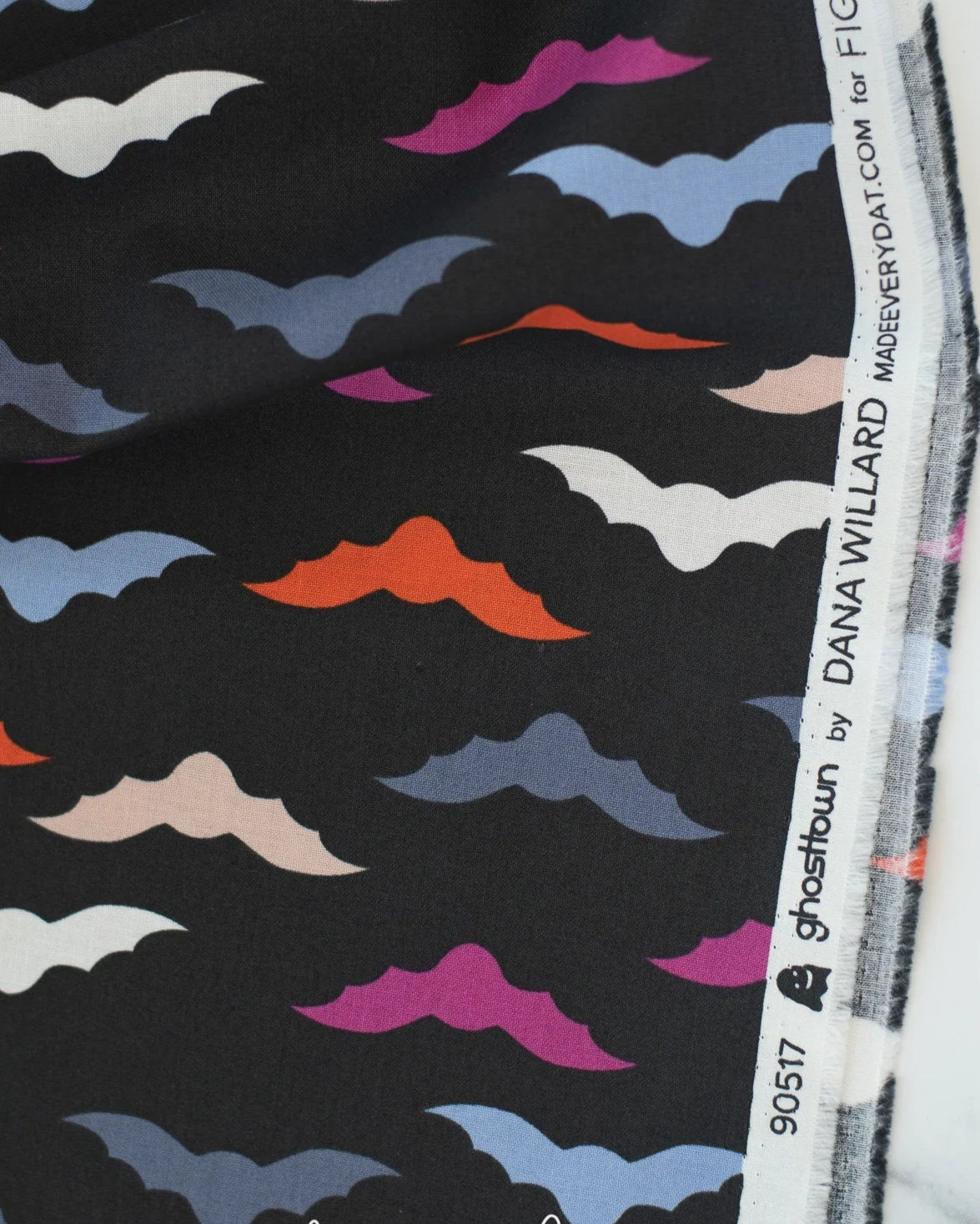 Fabric with colorful bat pattern and label on a black background