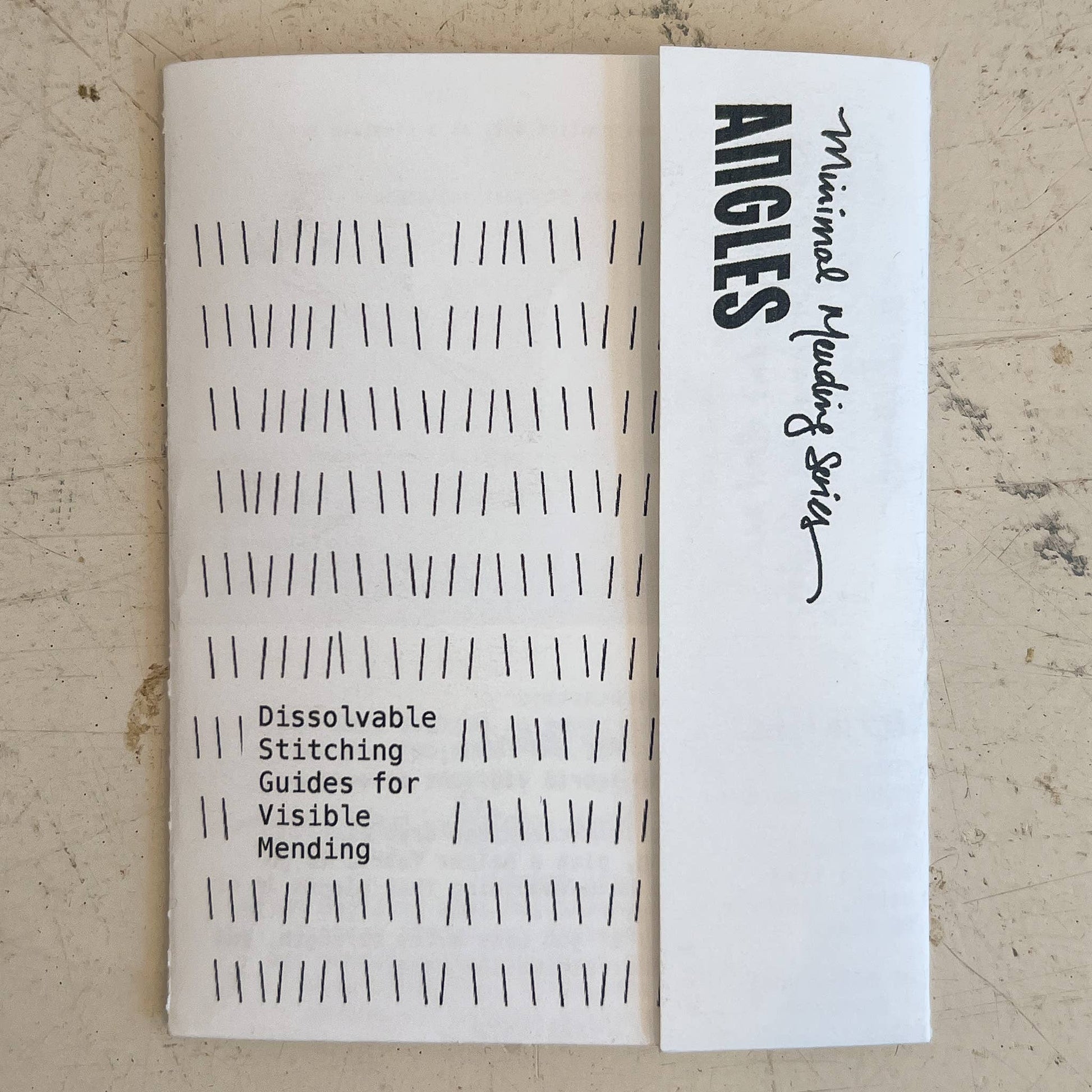 Sheet of dissolvable stitching guides with 'Angies' branding on a textured surface