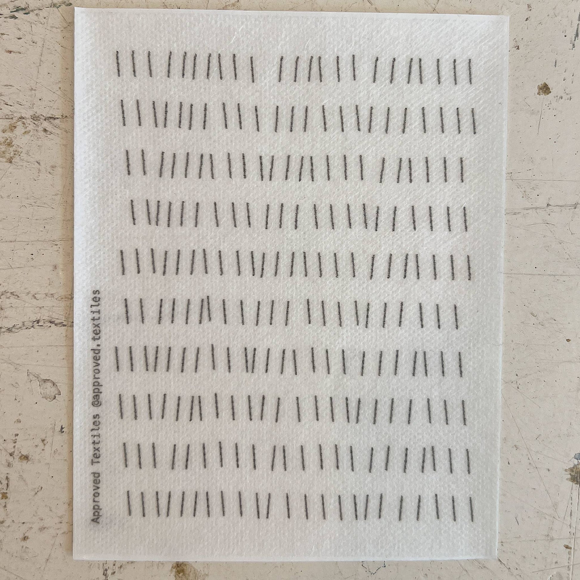 Textile sample with black line pattern on a beige background