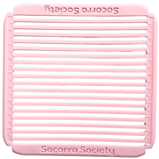Pink silicone mat with 'Socorro Society' branding on a white background