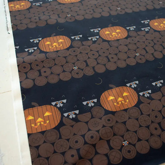 Halloween-themed fabric with pumpkins and ghosts on a dark . Raccoons background