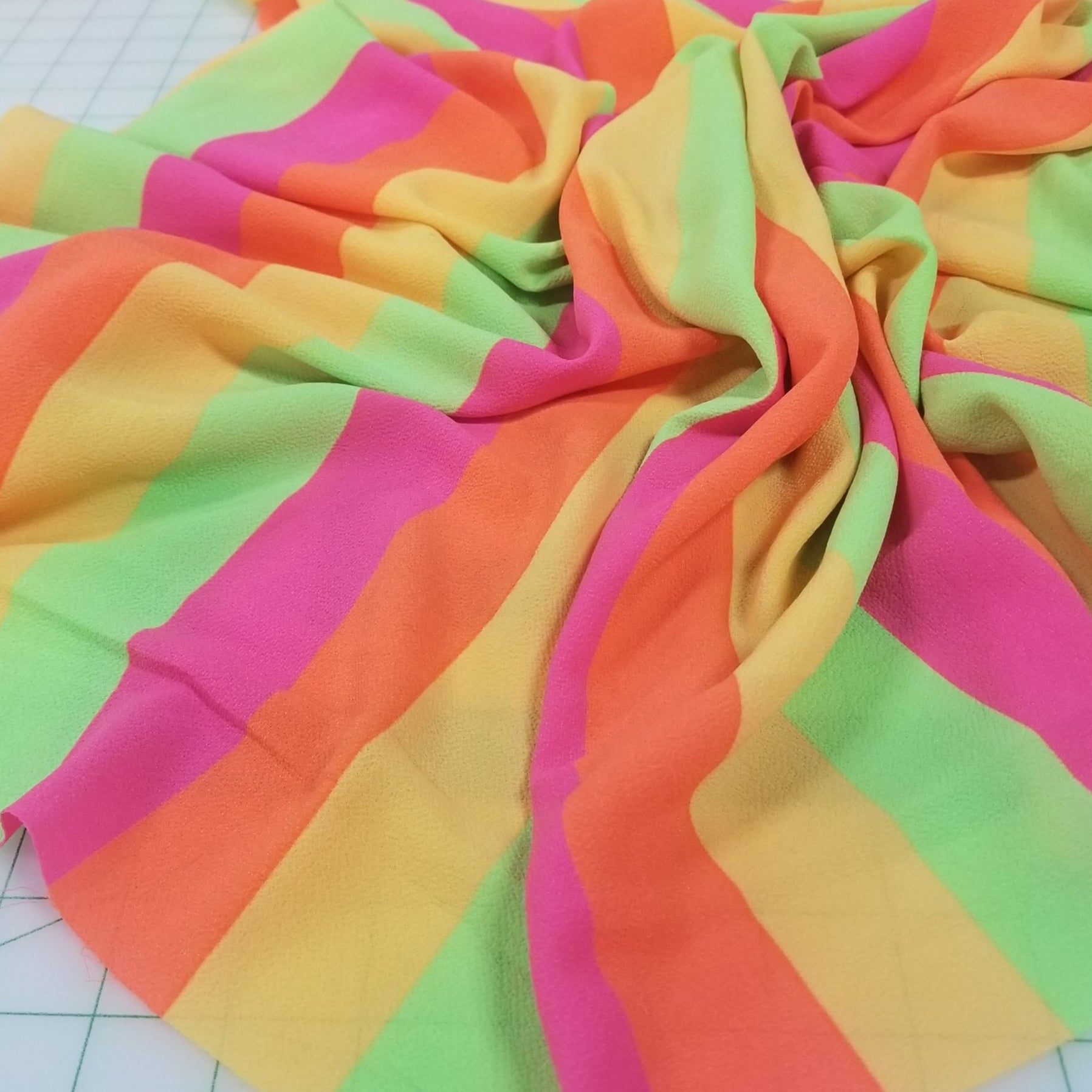 Colorful striped fabric on a cutting mat. LA Finch Fabrics, Deadstock fabrics woven