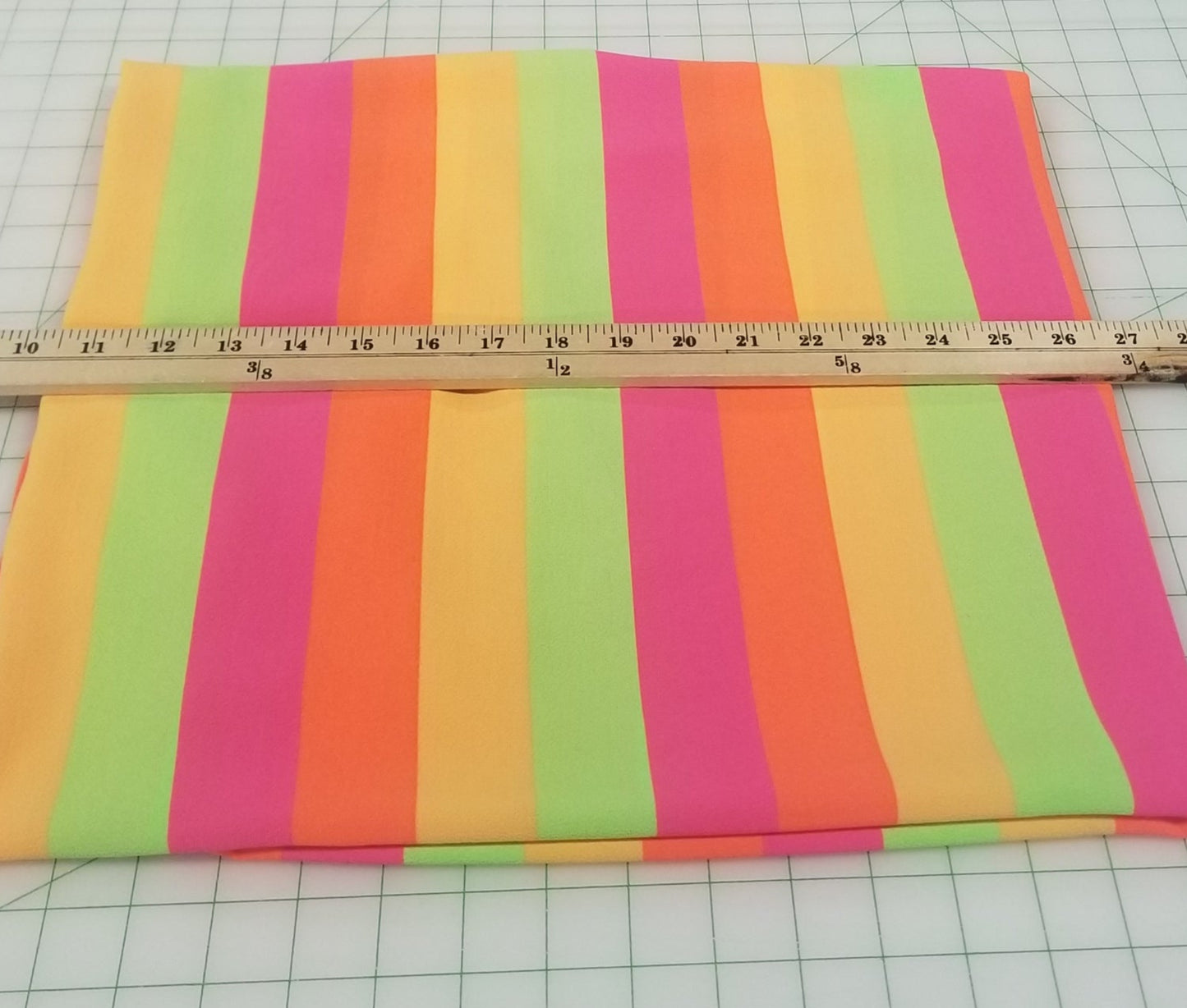 Colorful striped fabric with a ruler on a grid background