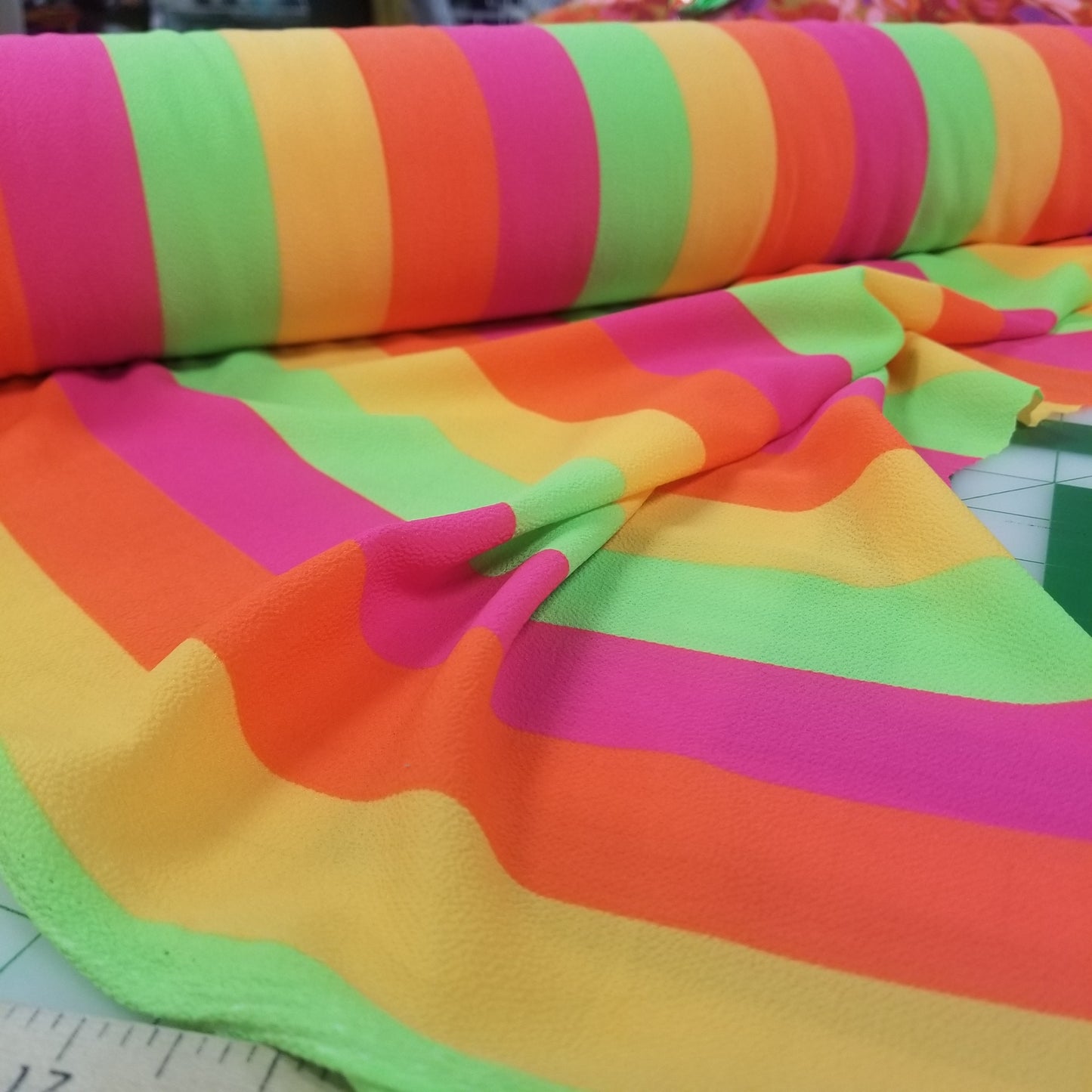Colorful fabric with stripes and patterns on a ruler background