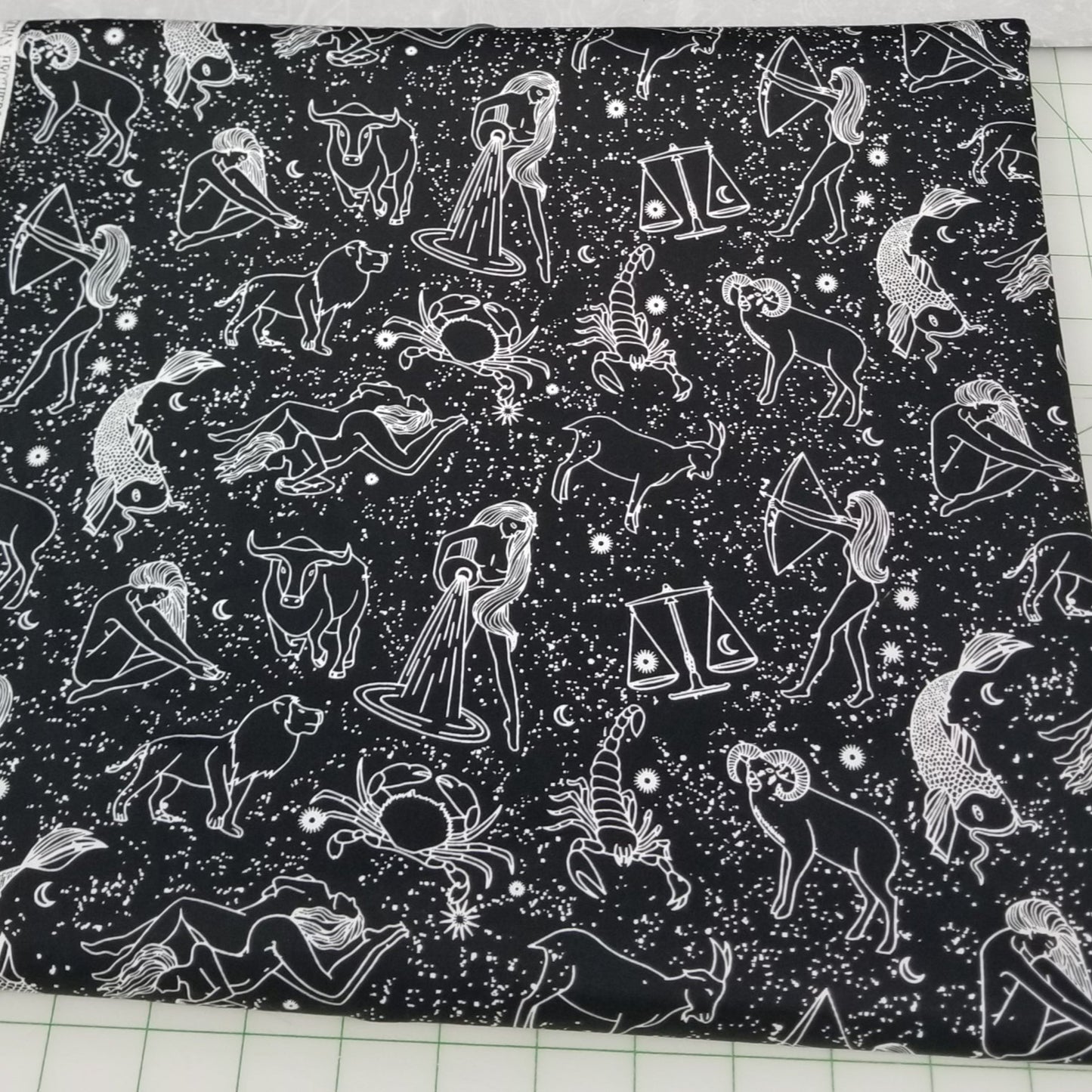 Black fabric with white zodiac pattern on a cutting mat