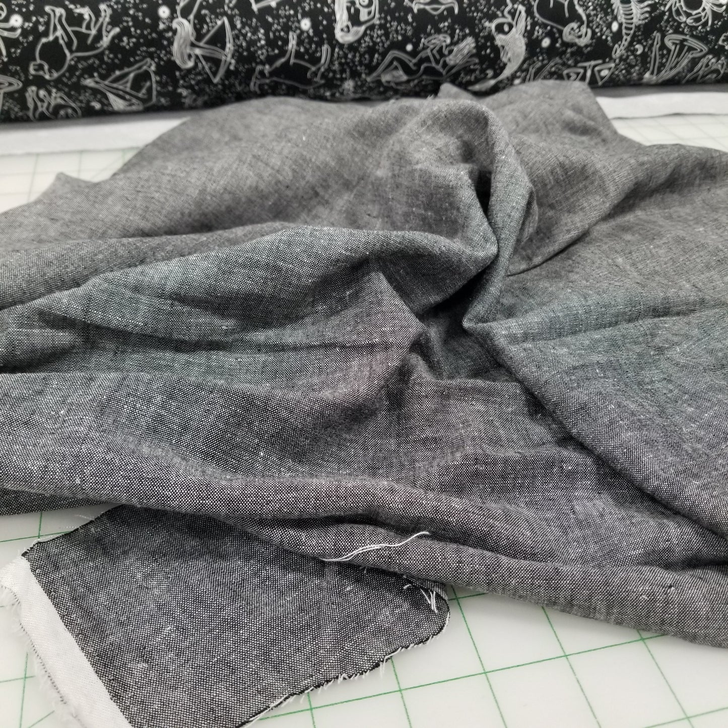 Gray fabric on a cutting mat with grid lines