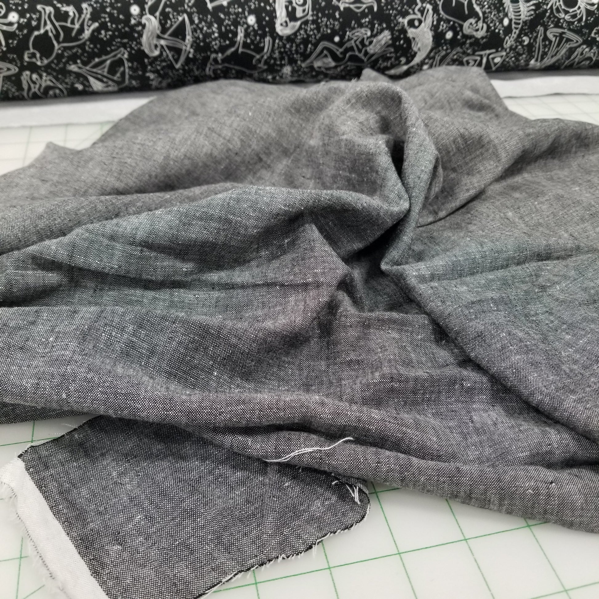 Gray fabric on a cutting mat with grid lines