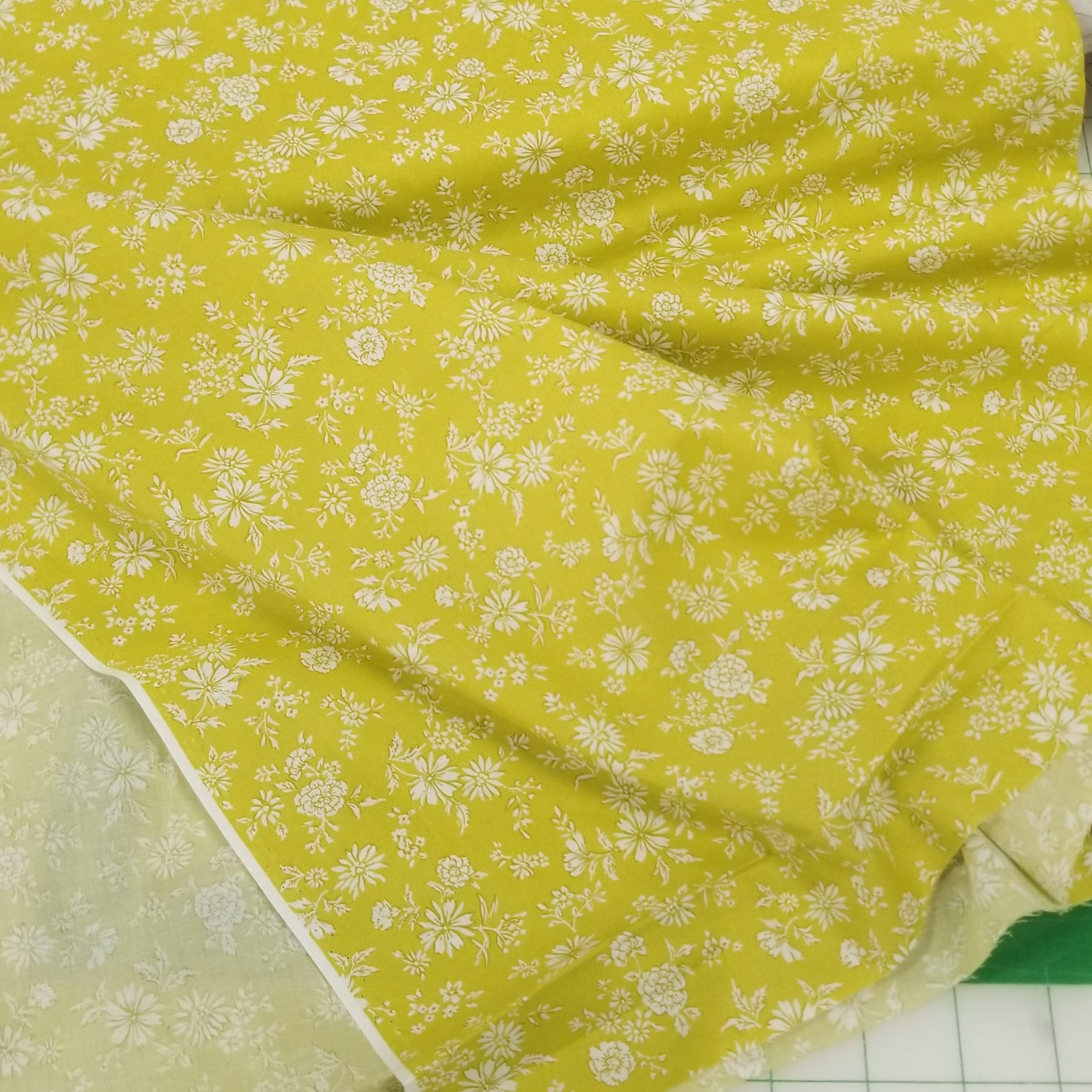 Yellow fabric with white floral pattern on a grid background