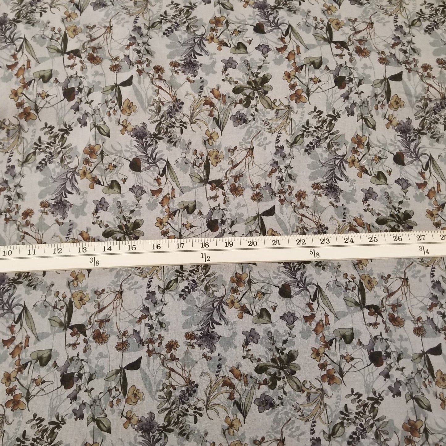Floral fabric pattern with a ruler for scale on a white background