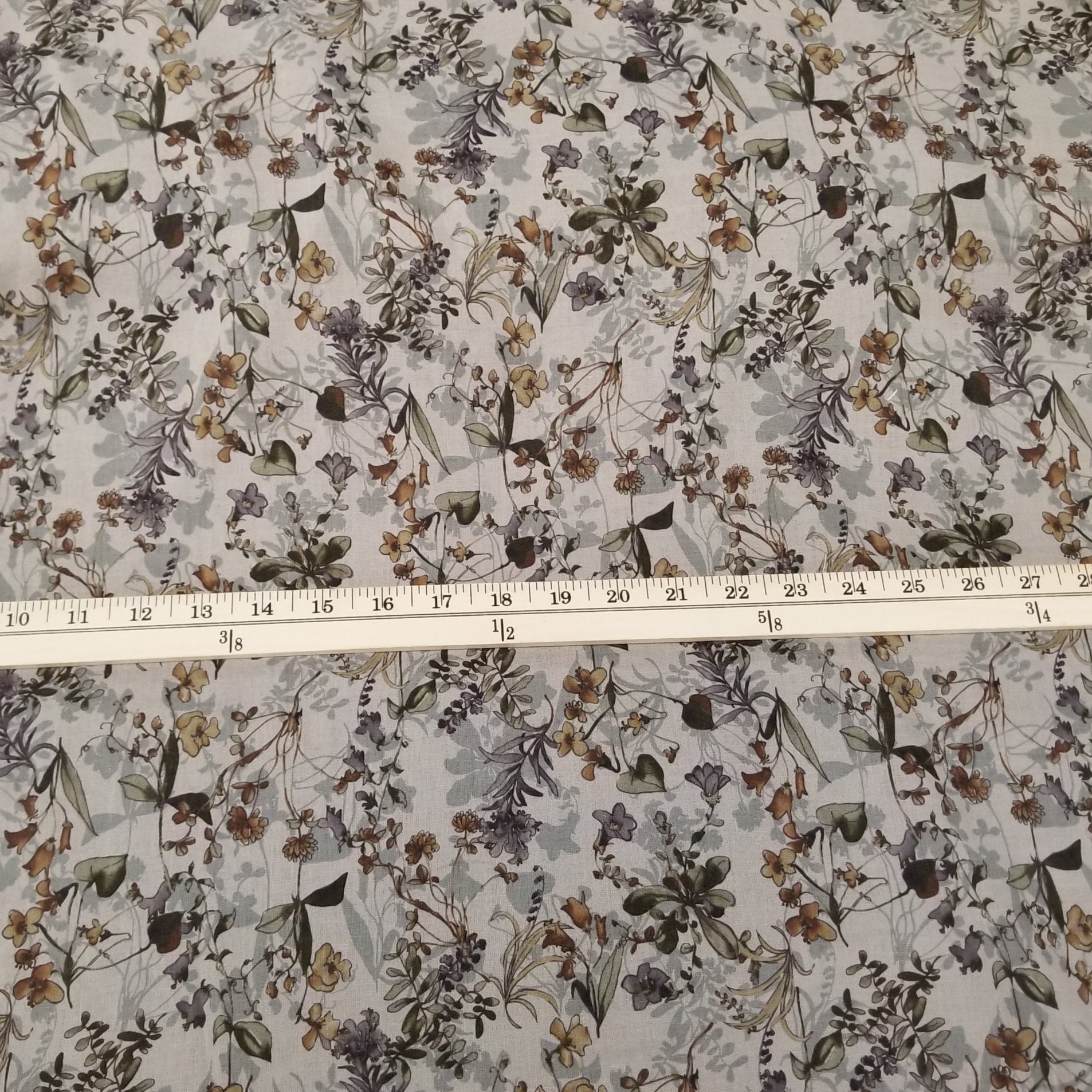 Floral fabric pattern with a ruler for scale on a white background