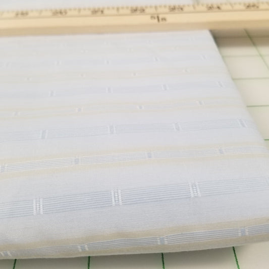 Close-up of a roll of white fabric with a grid background