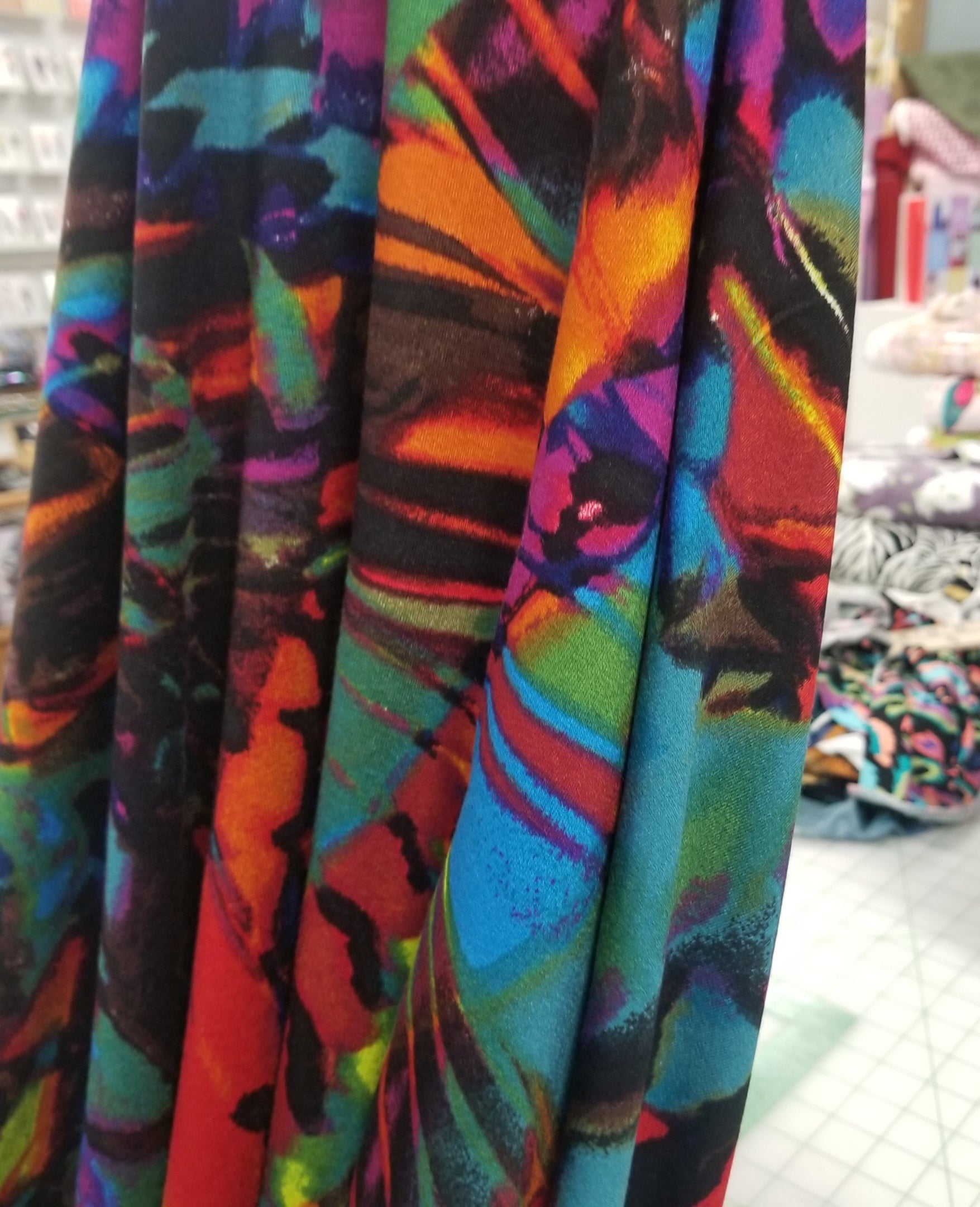 Stack of colorful fabric with abstract pattern on a table.