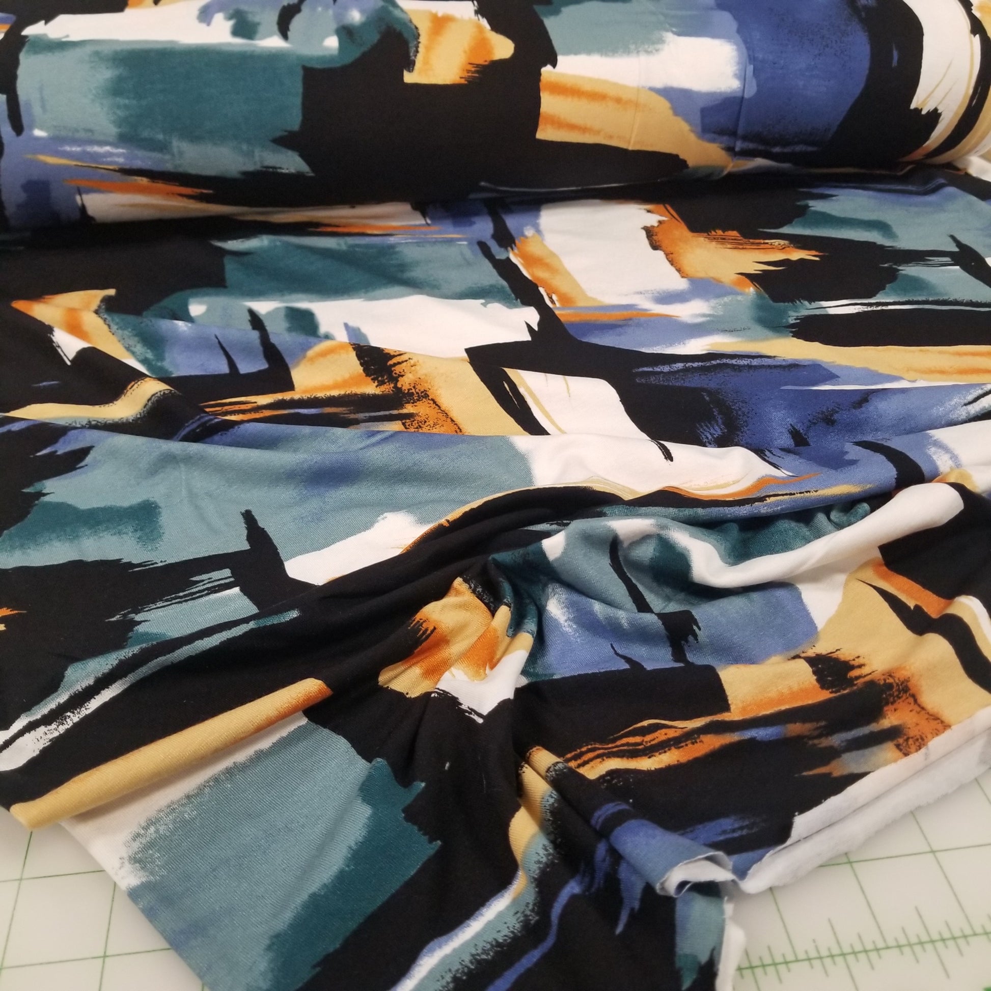 Close-up of fabric with abstract design featuring black, blue, and orange colors.