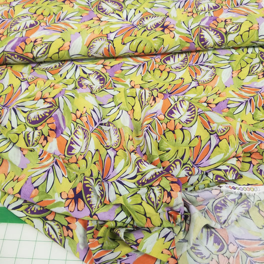 Colorful fabric with a tropical leaf pattern on a grid background