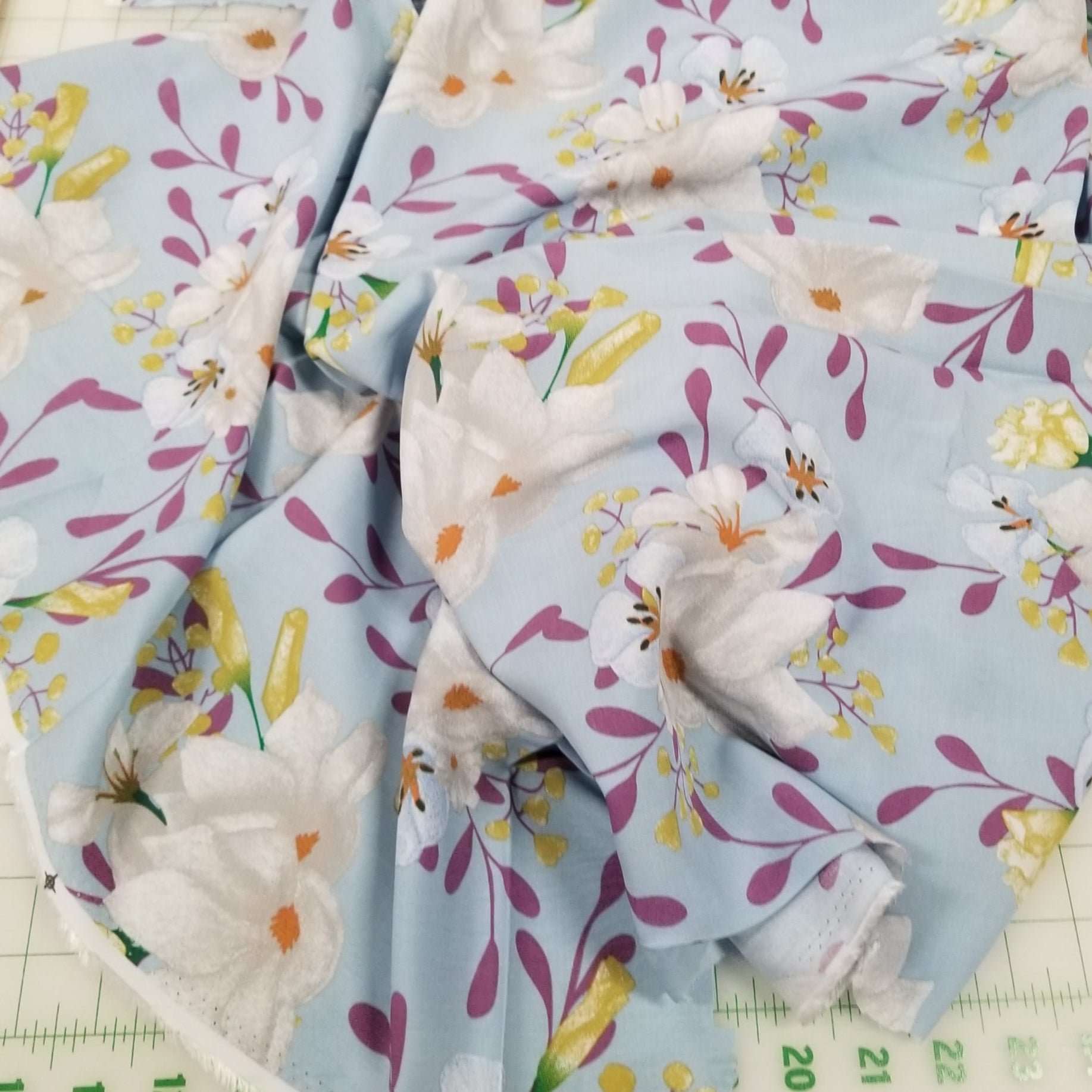 Floral fabric with a blue background on a cutting mat