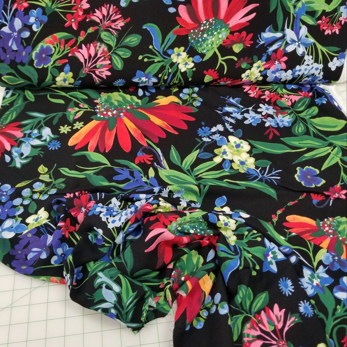 Colorful floral fabric on a black background with grid lines