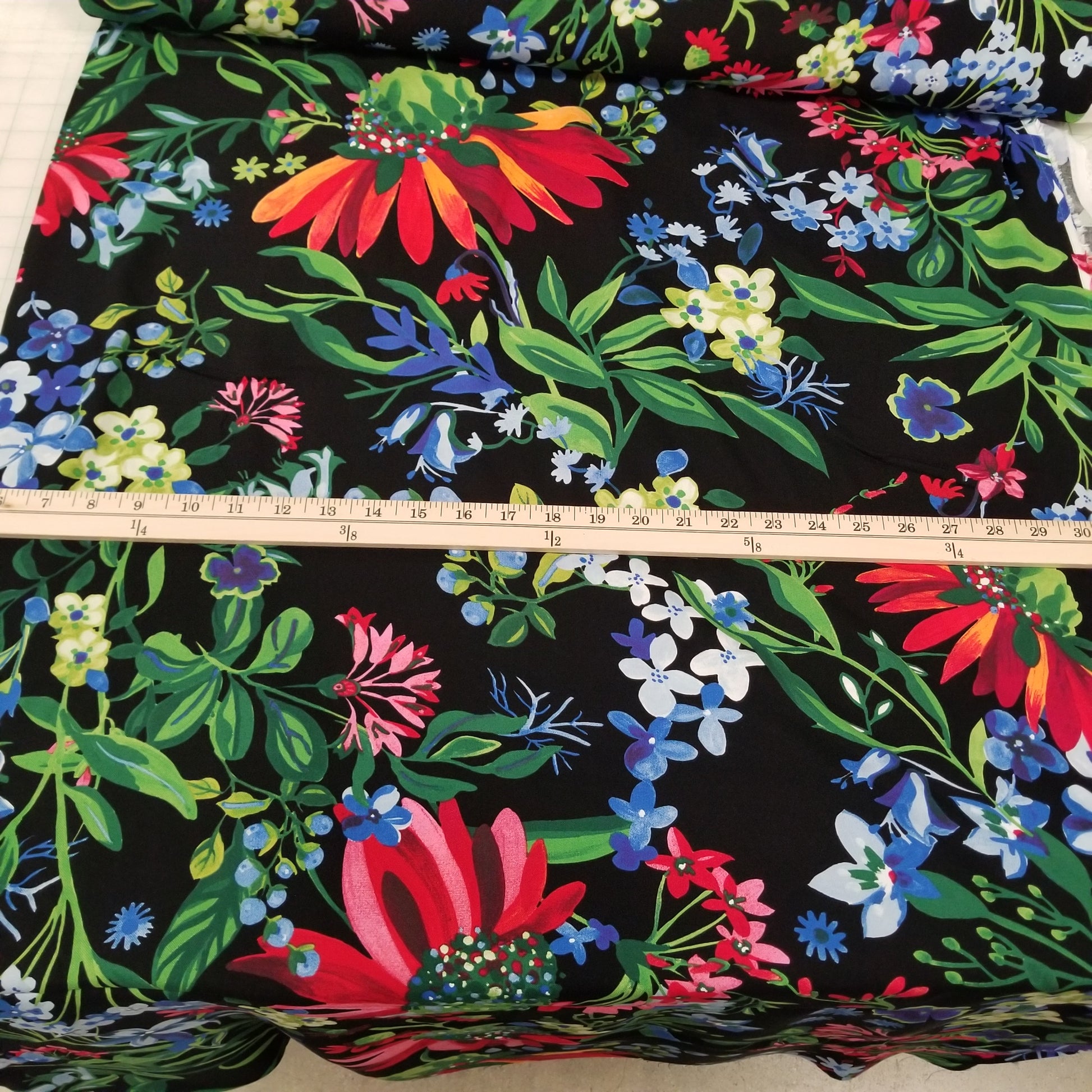 Floral fabric with a ruler for scale on a black background
