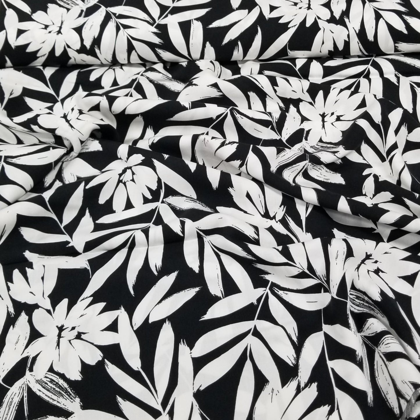 Black fabric with white leaf pattern on a floral background