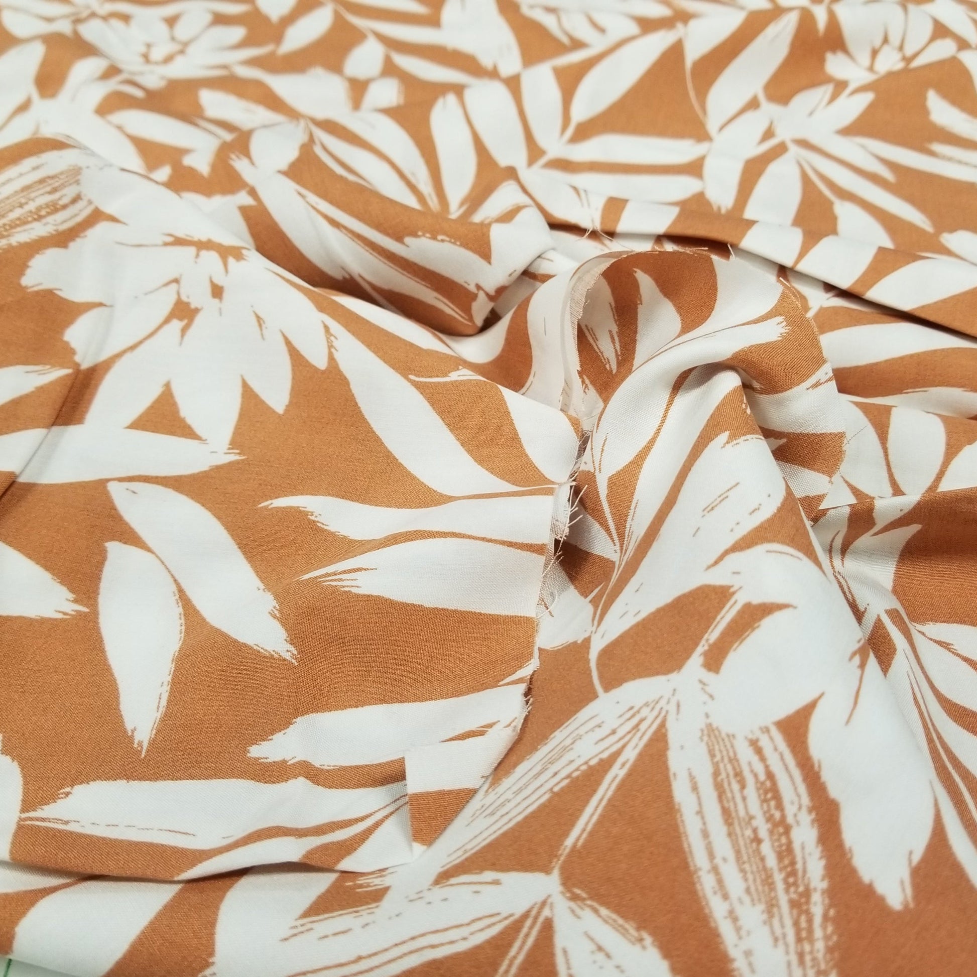 Fabric with white leaf pattern on a brown background