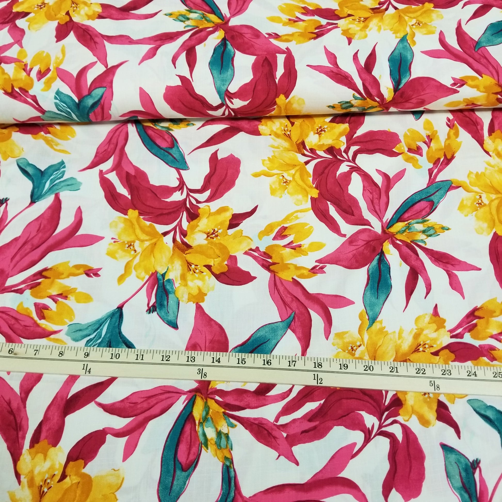 Floral fabric with pink, yellow, and green flowers on a white background, measured with a ruler.