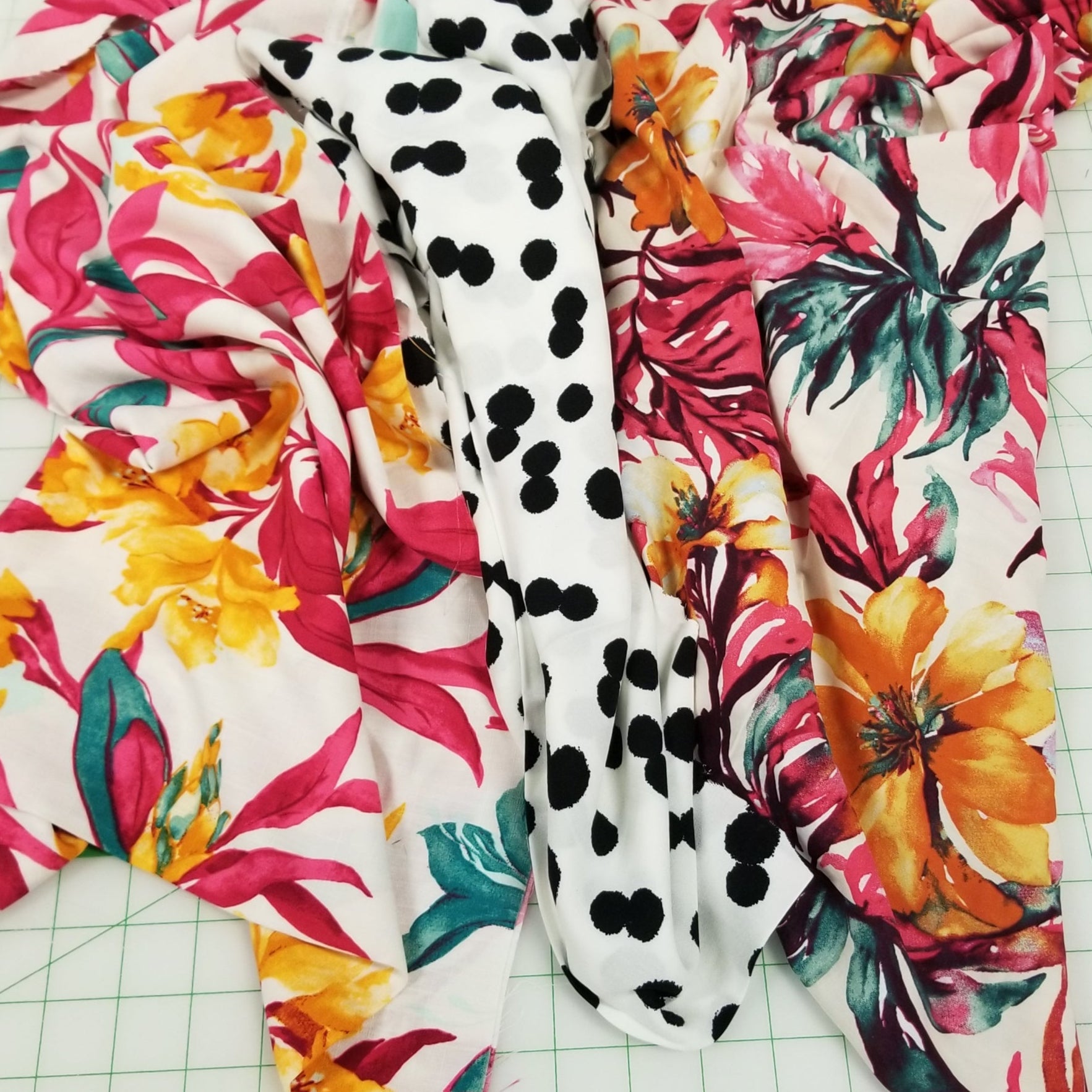 Colorful floral and polka dot fabric on a grid background