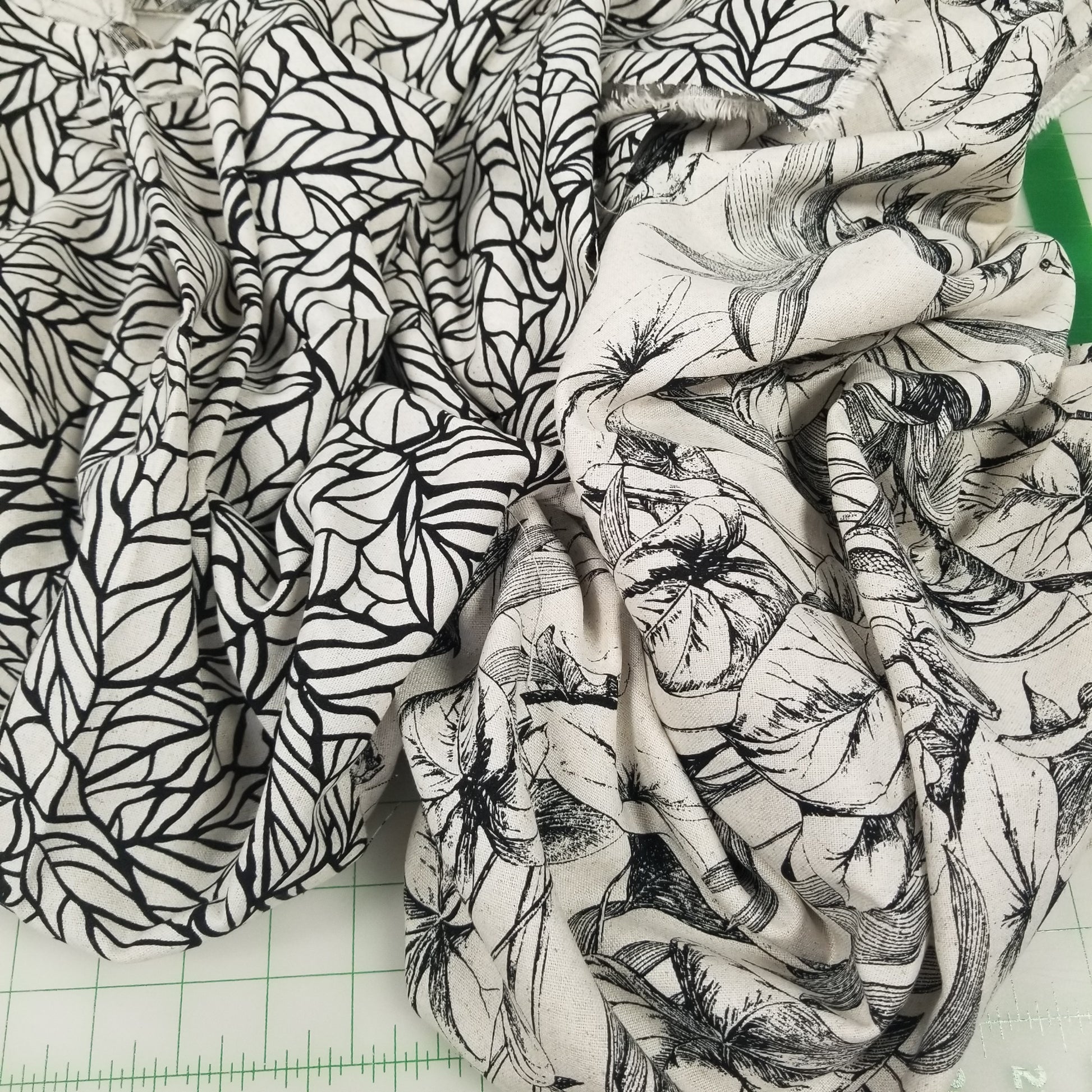 Black and white leaf pattern fabric on a green cutting mat