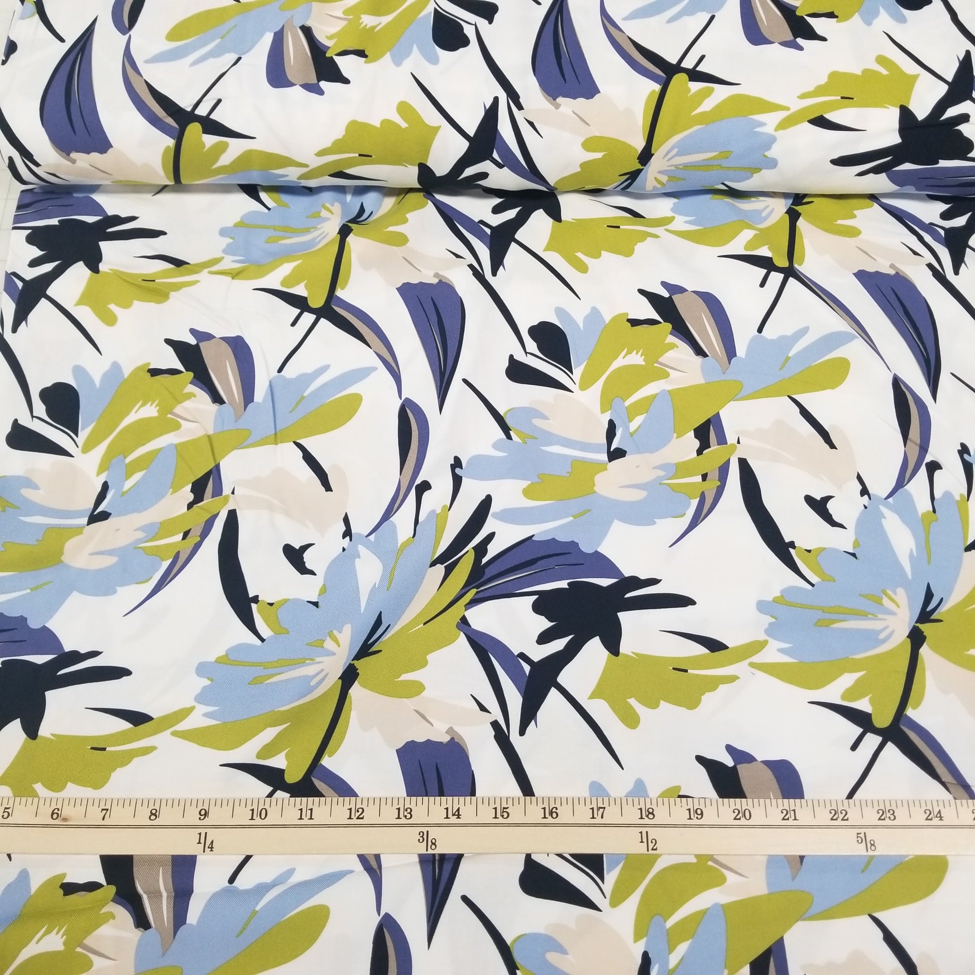 Fabric with abstract leaf pattern and a ruler for scale on a white background