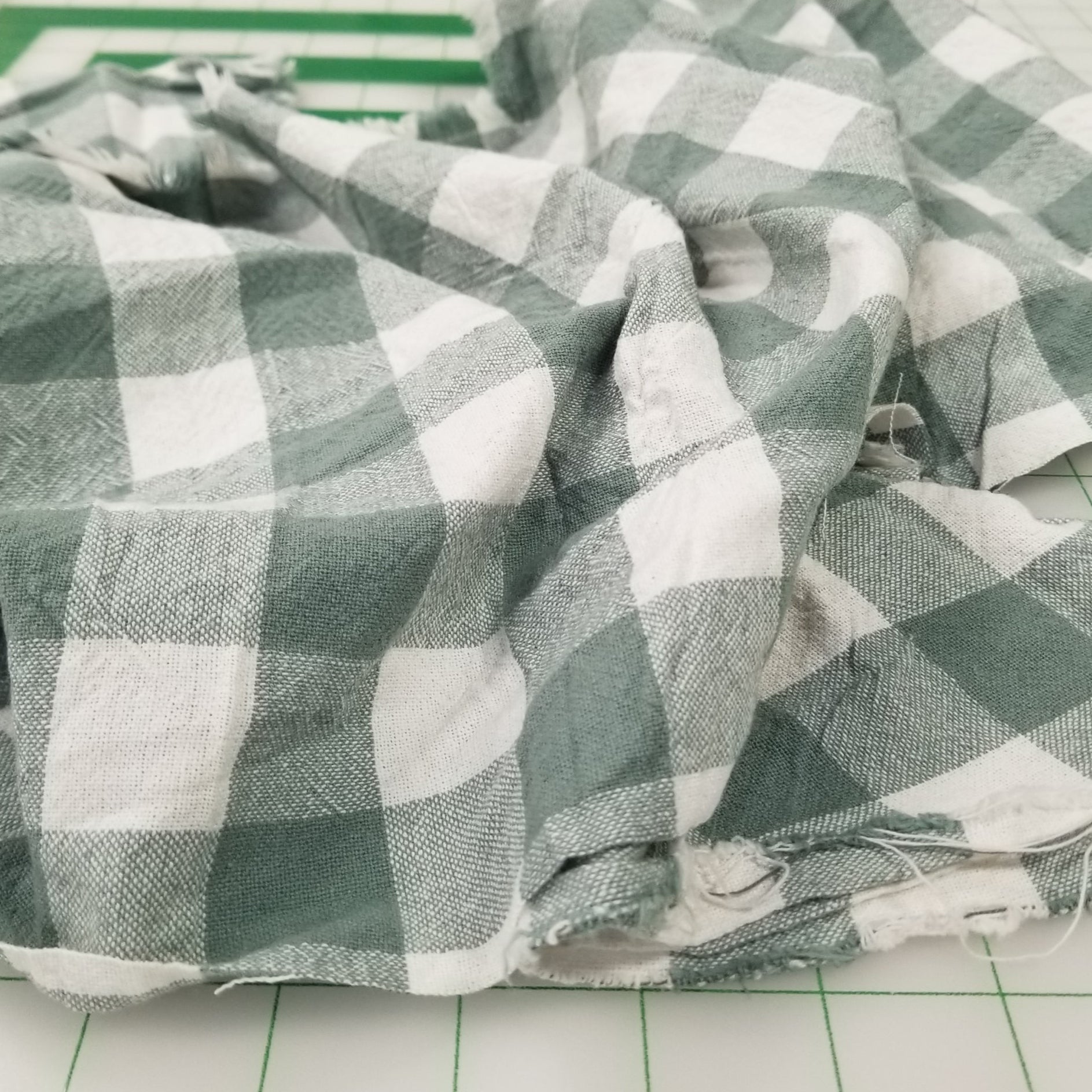Green and white checkered fabric on a tiled floor