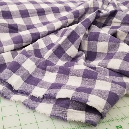Purple and white checkered fabric on a cutting mat with measurements. organic fabric