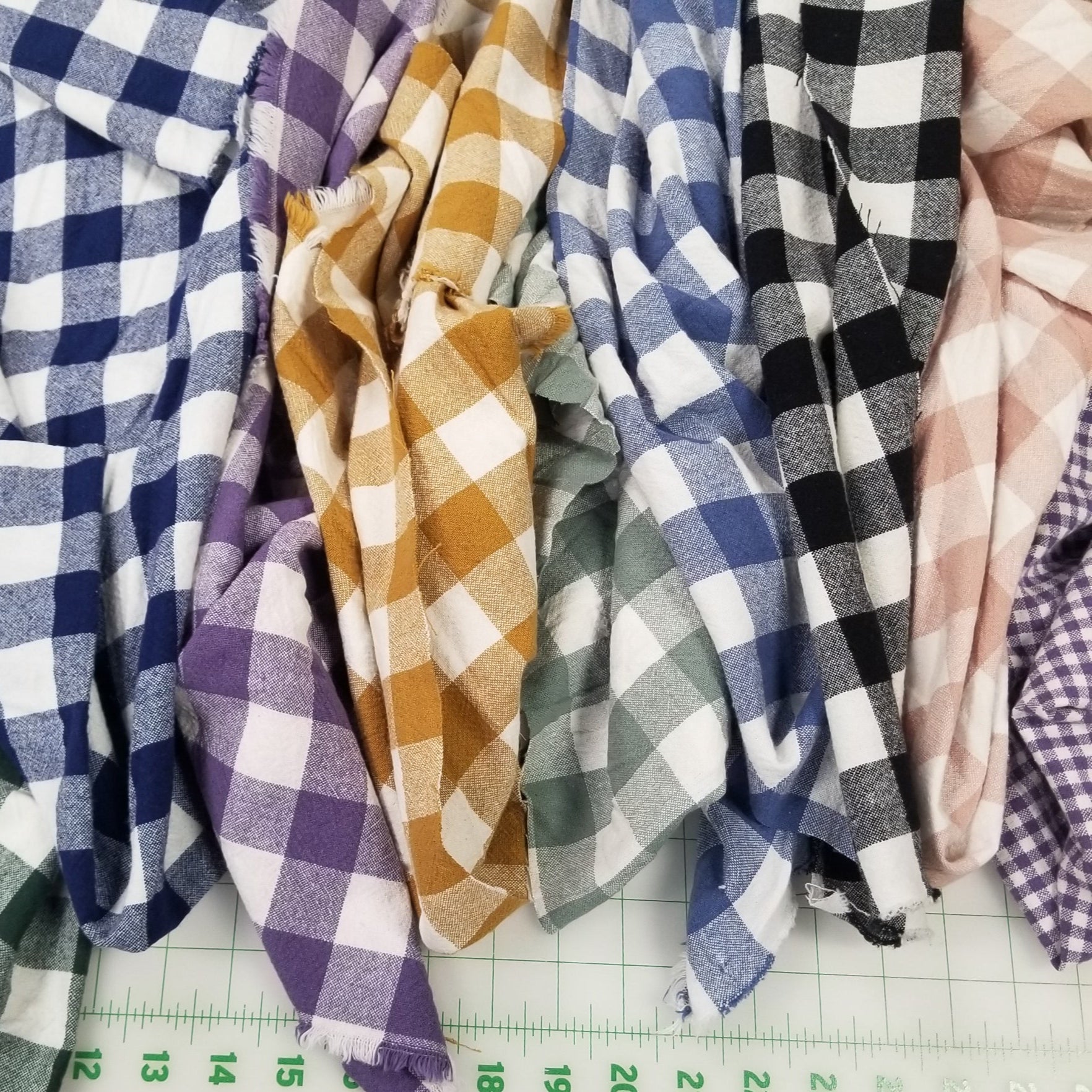 Stack of checkered fabrics with a ruler on a concrete surface