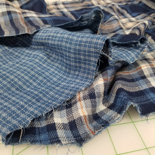 Close-up of blue plaid fabric on a cutting mat