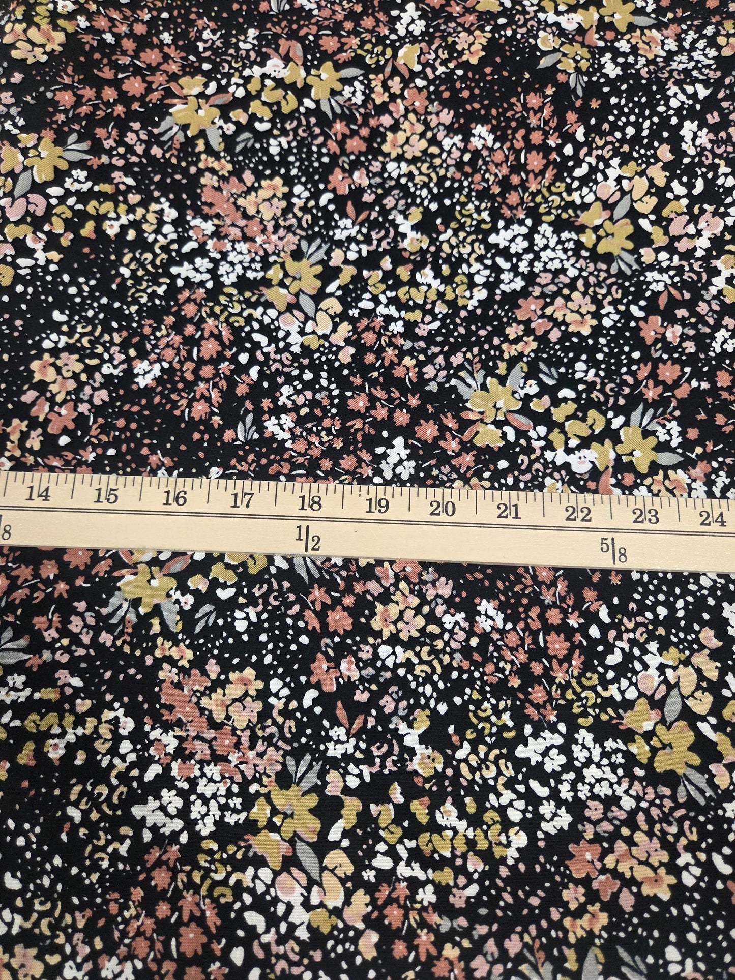 Floral fabric with a measuring tape for scale on a black background