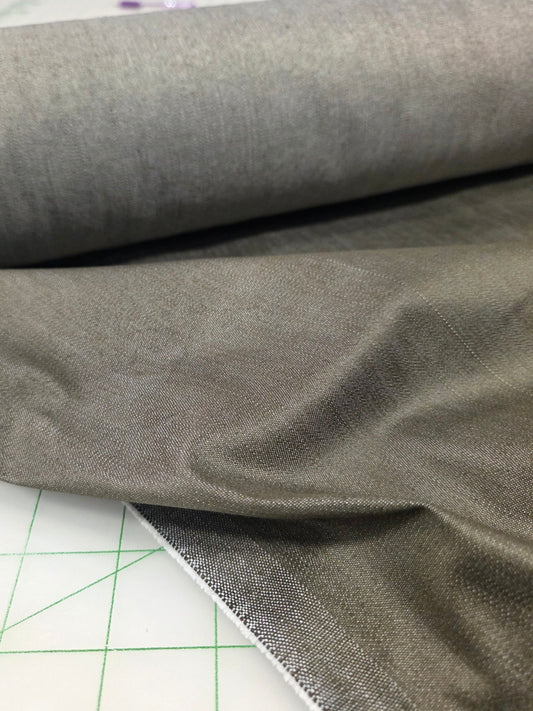 Close-up of gray fabric on a cutting mat with grid lines