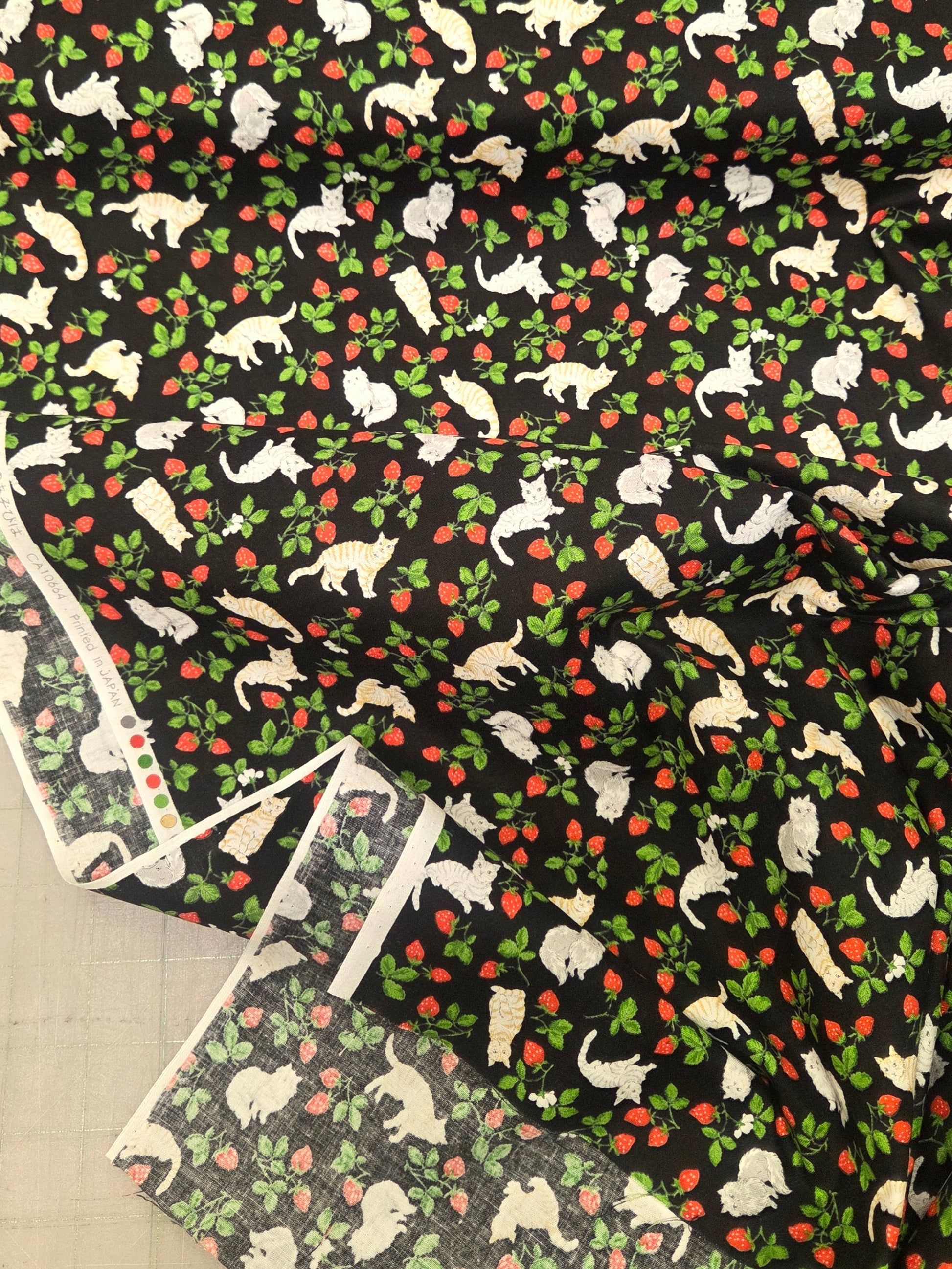 Patterned fabric with dogs and apples on a black background