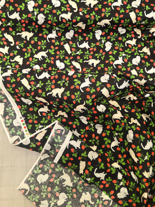 Patterned fabric with dogs and apples on a black background