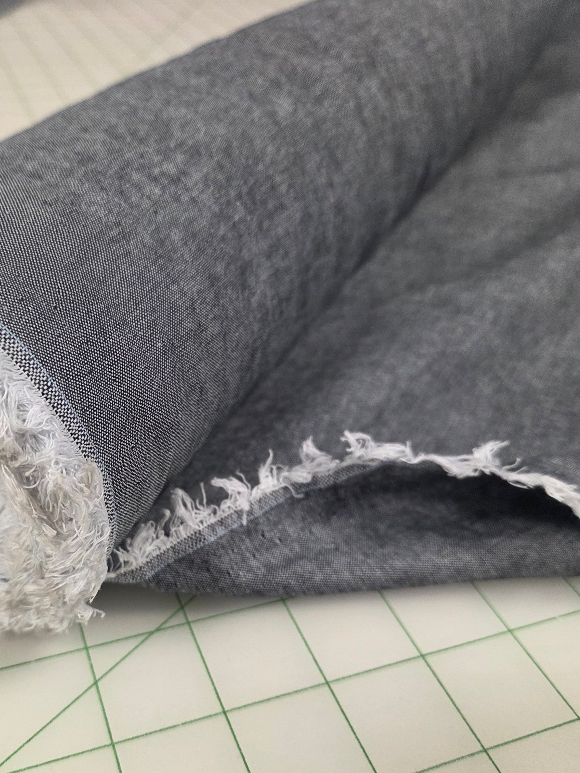Gray fabric with lace trim on a grid background