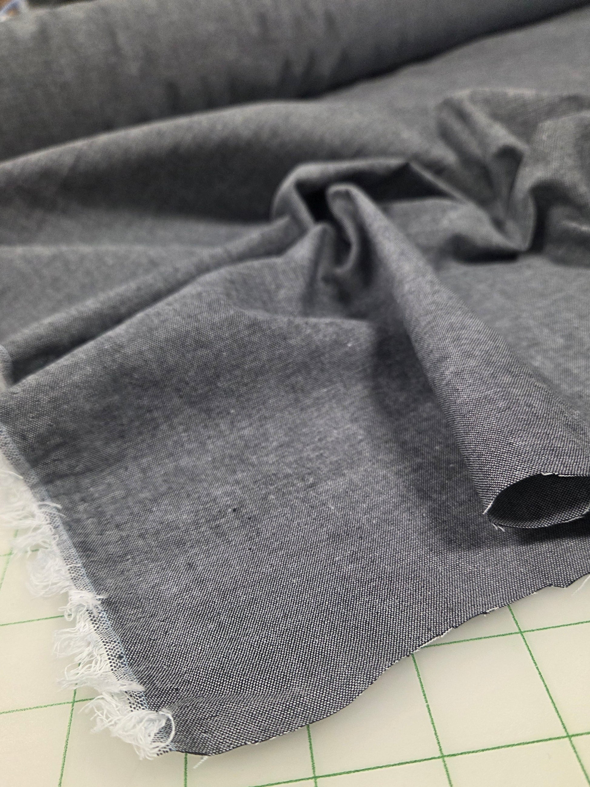 Gray fabric with lace trim on a green grid background