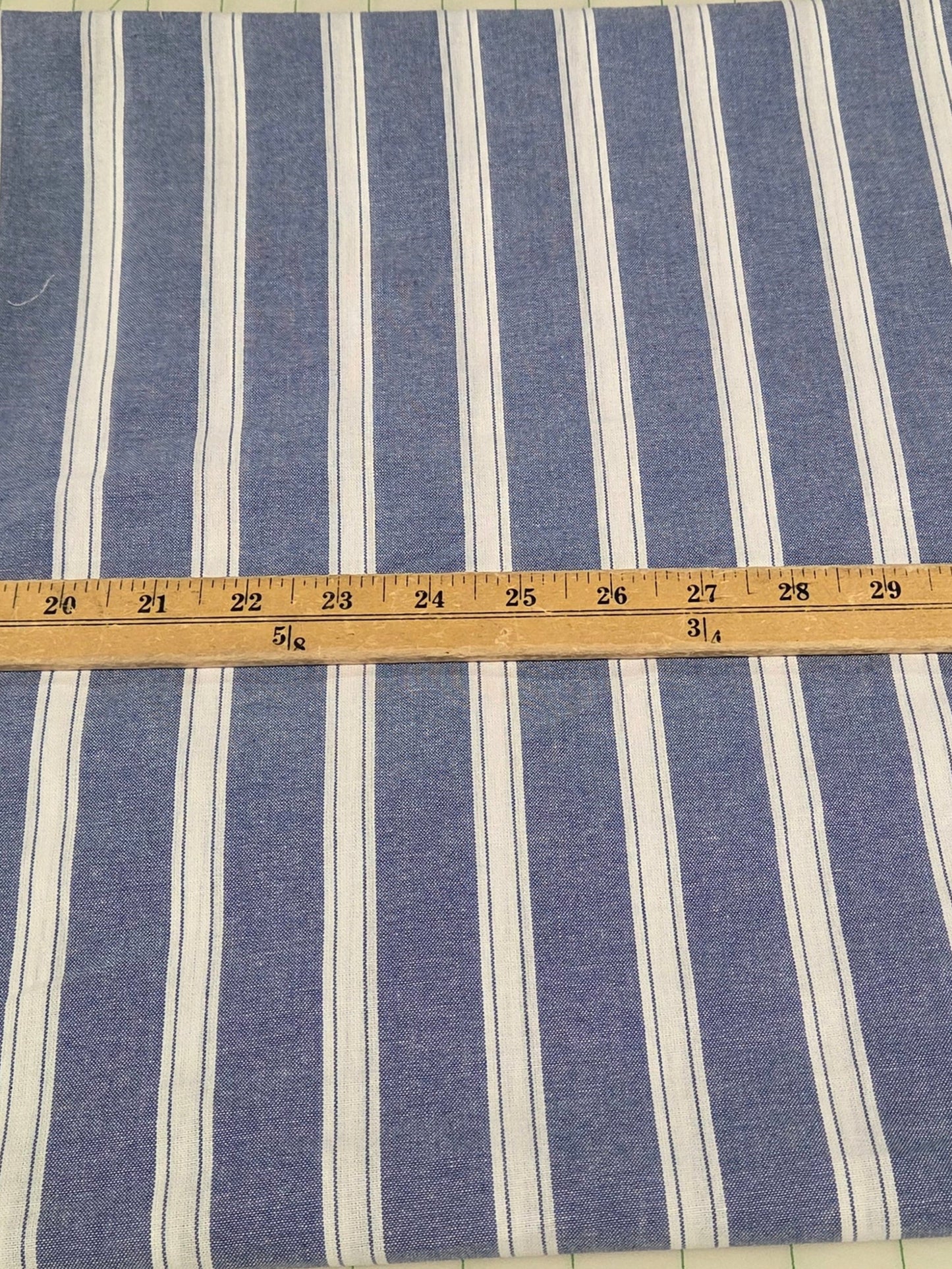 Blue and white striped fabric with a ruler for scale on a grid background