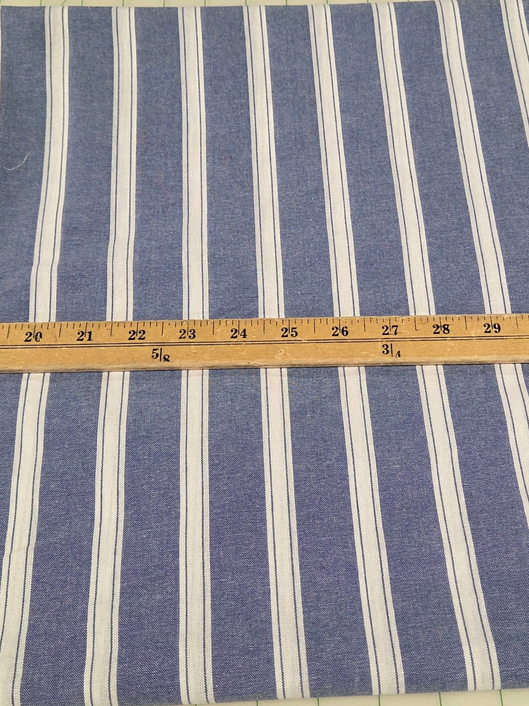 Blue and white striped fabric with a ruler for scale on a grid background