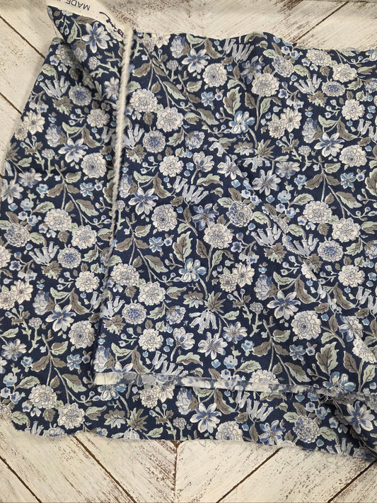 Floral patterned fabric on a wooden surface. LA Finch Fabric