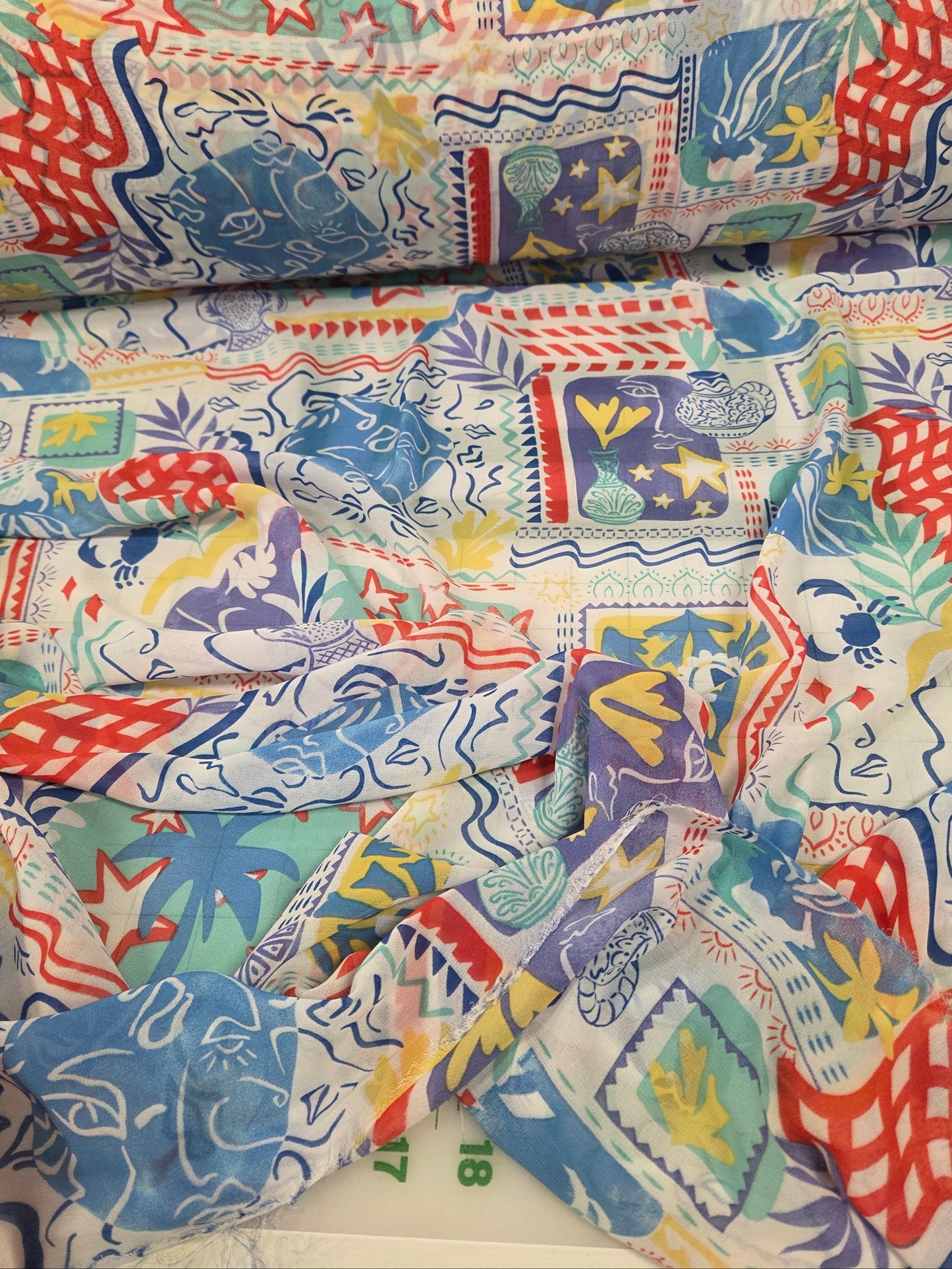 Colorful patterned fabric with various designs on a white background