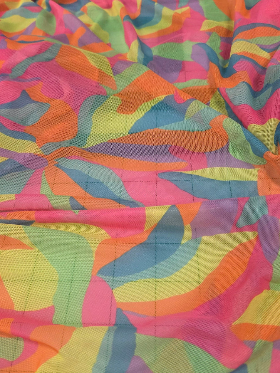 Colorful patterned fabric draped over a surface with tiled background. LA Finch Fabrics