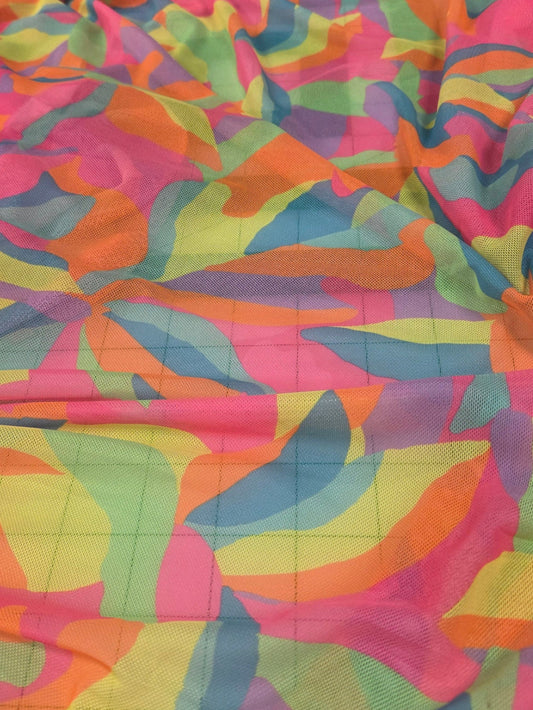 Colorful patterned fabric draped over a surface with tiled background. LA Finch Fabrics