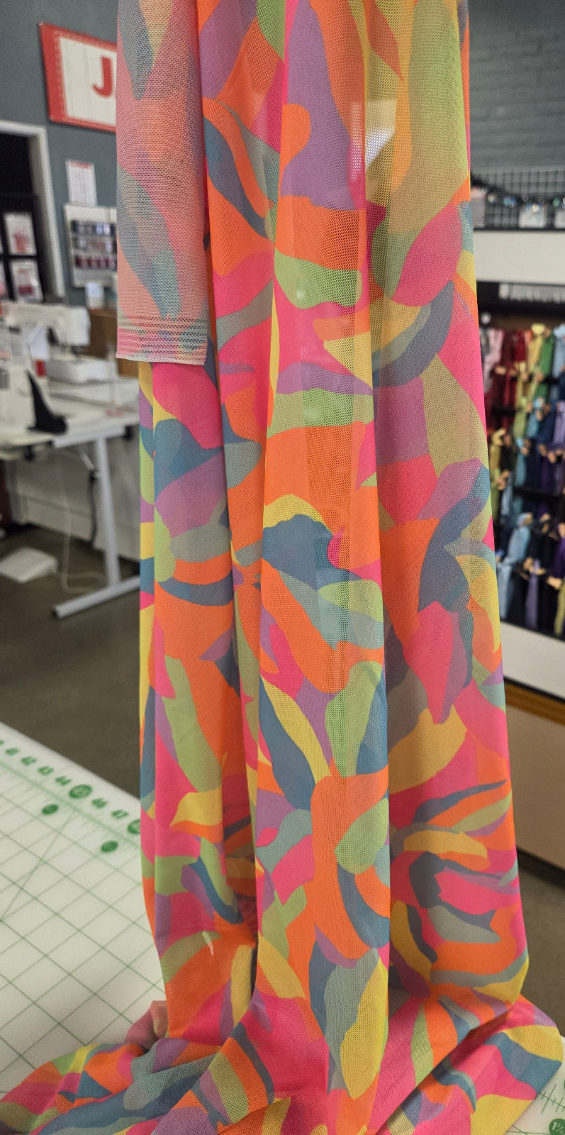 Colorful fabric with abstract pattern in a store setting. LA inch Fabrics