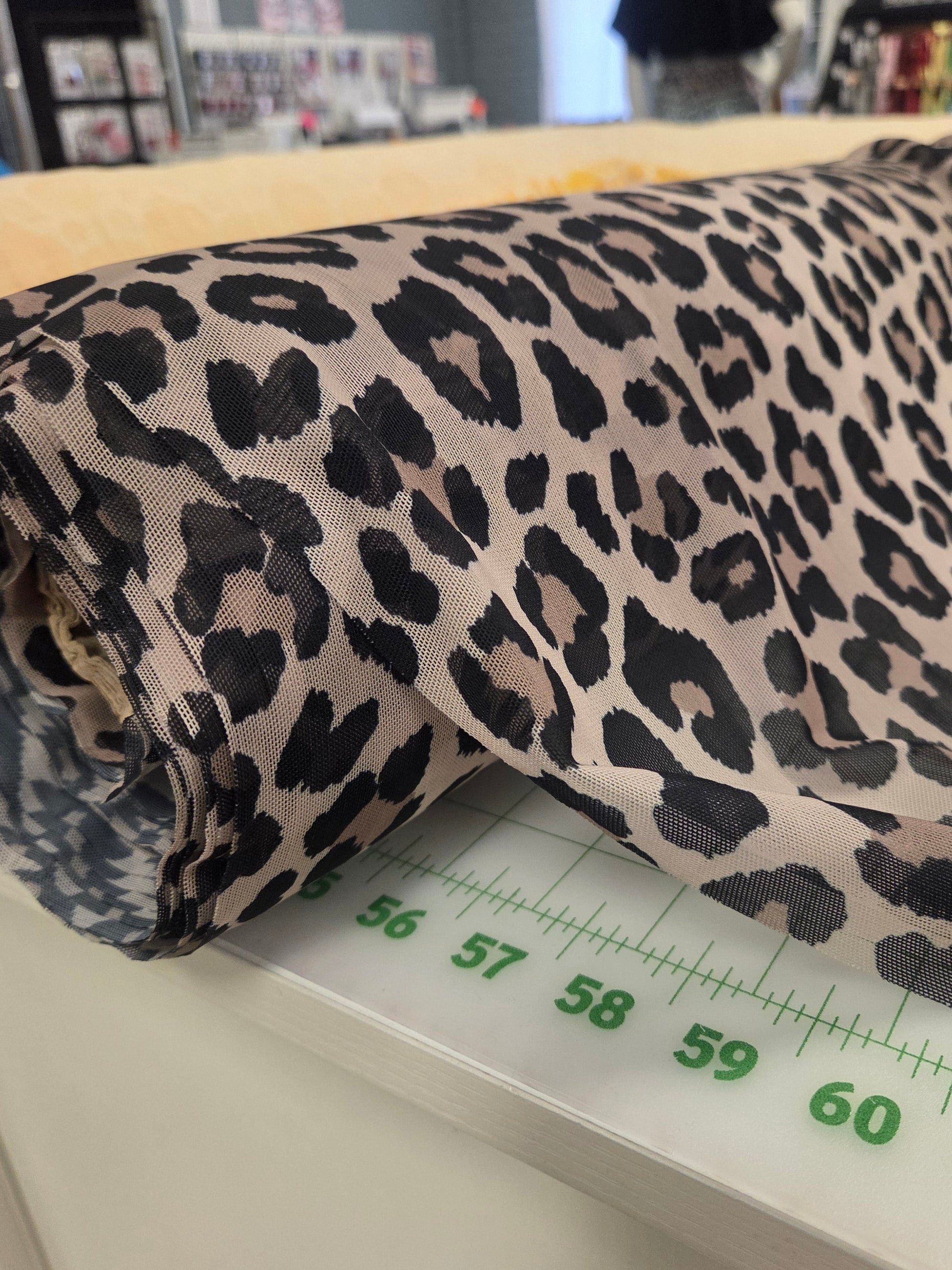 Leopard print fabric on a measuring scale with a blurred background. Designer Deadstock fabric. LA Finch