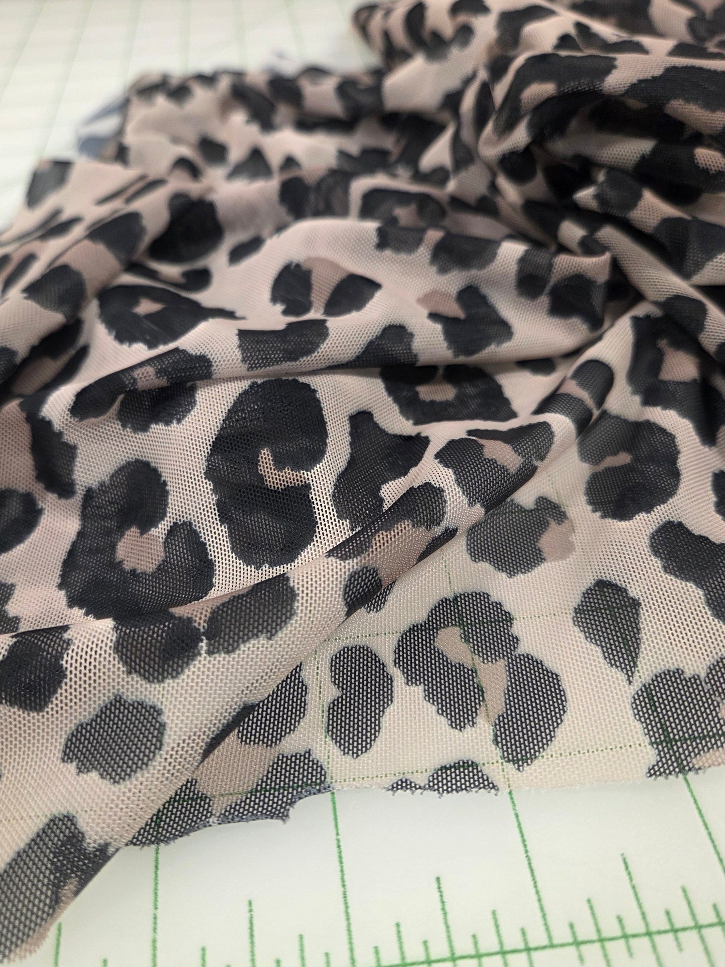 Leopard print fabric with a ruler for scale on a white background