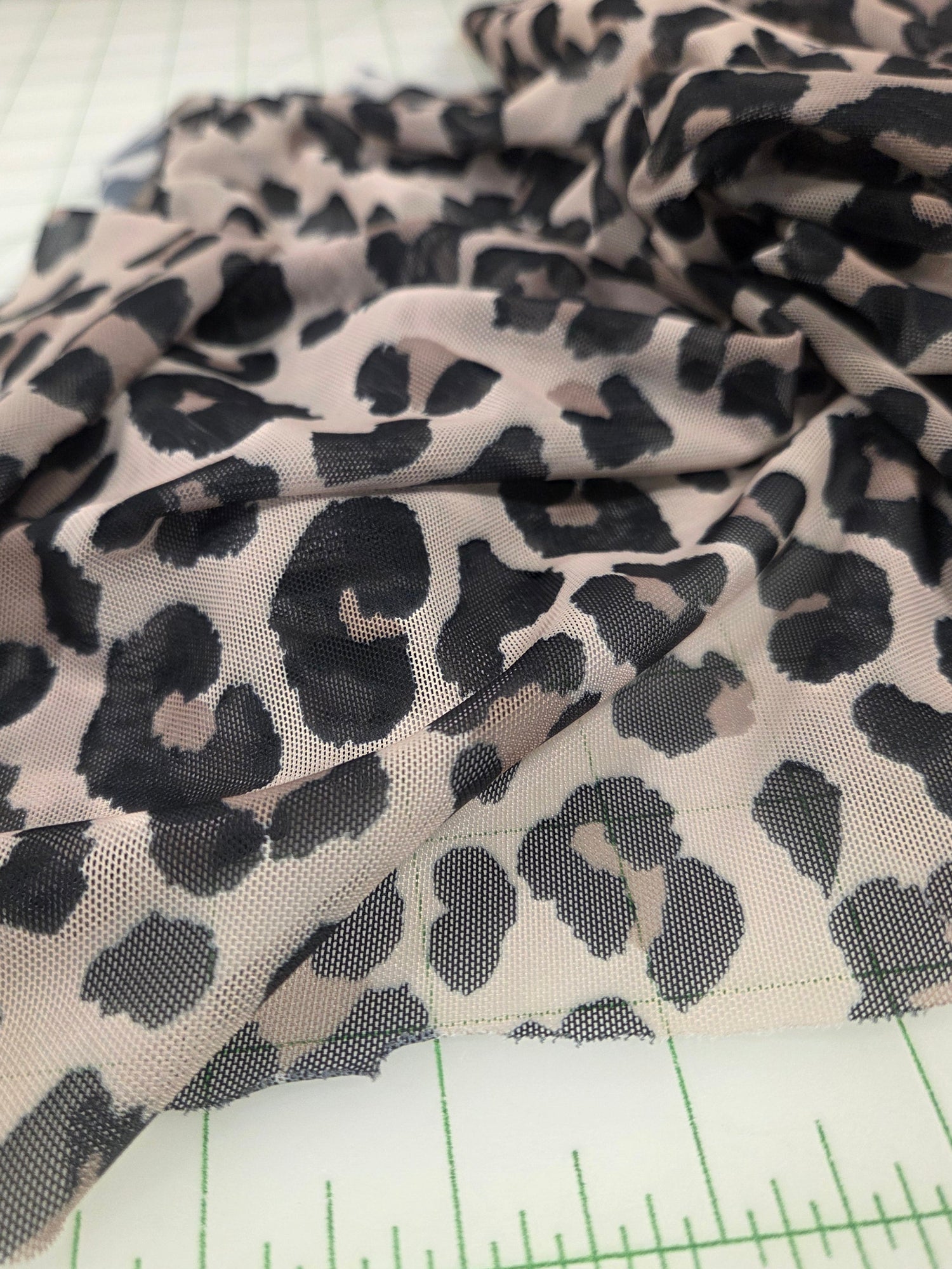 Leopard print fabric with a ruler for scale on a white background