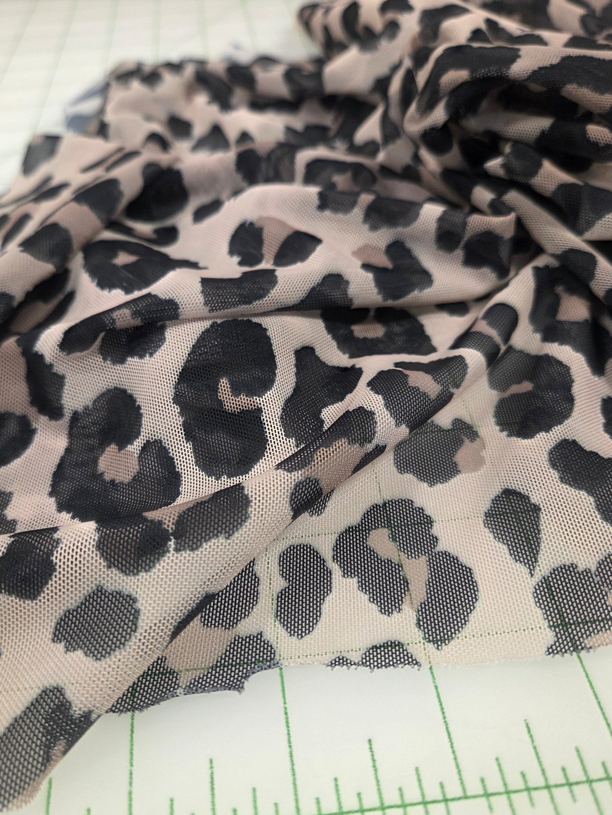 Leopard print fabric with a ruler for scale on a white background