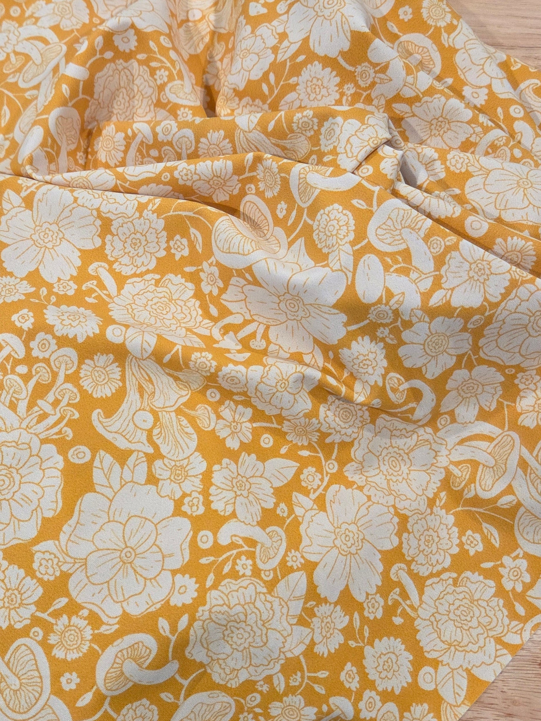 Yellow floral fabric on a wooden surface
