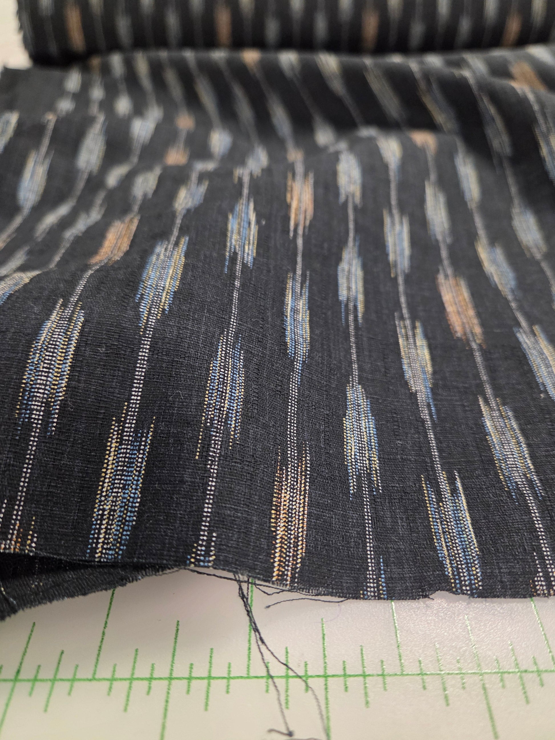 Textured fabric with a pattern next to a measuring ruler. Japan Fabric dobby